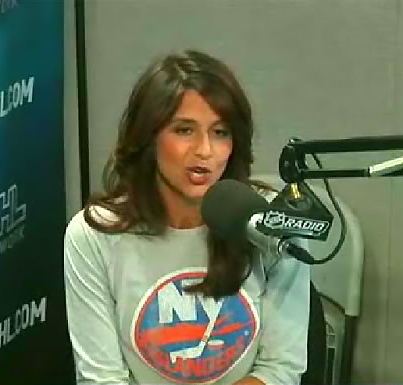 Deb Placey delivering a news report while wearing a white printed sweatshirt