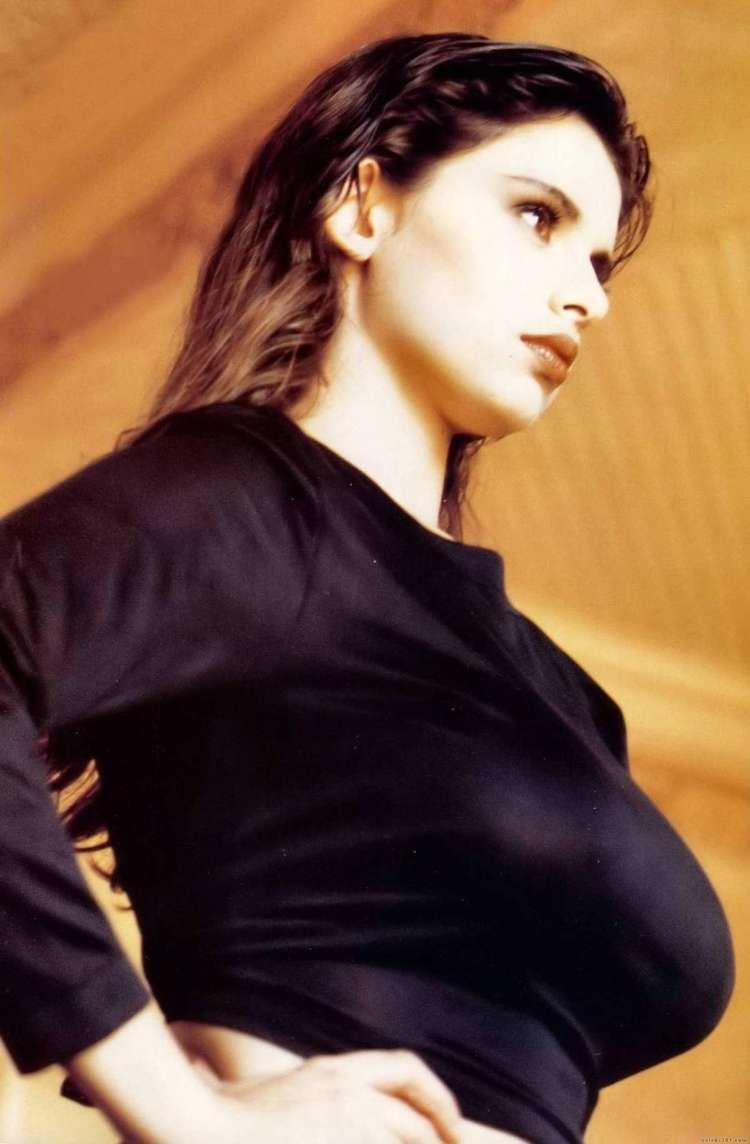 Debora Caprioglio wearing a black long-sleeved shirt (side view)