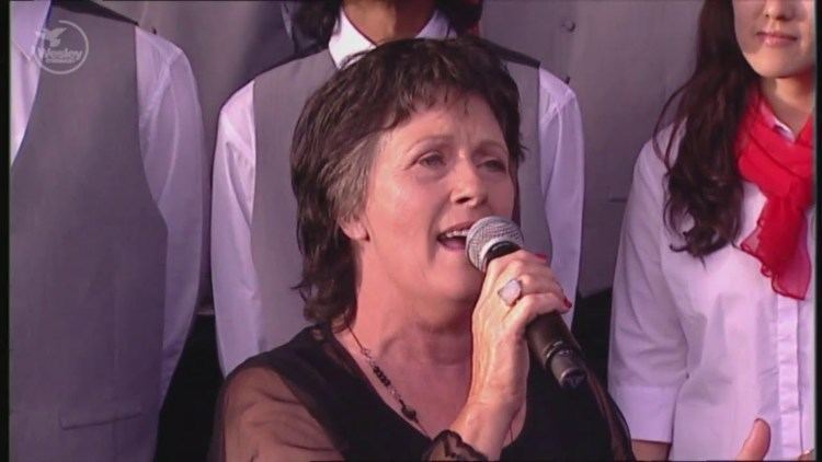 Debra Byrne singing while wearing black blouse