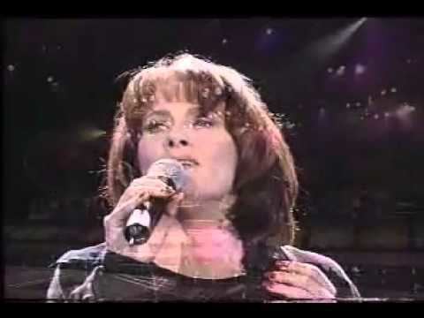 Debra Byrne while singing and wearing black long sleeves