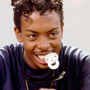 Dedrick D. Gobert as "Dooky" in the 1991 film Boyz n the Hood with curly hair and wearing a purple shirt.