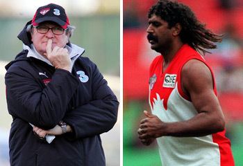 On the left, a man wearing a cap, a black jacket, and a watch while holding his chin. On the right, Derek Kickett with curly black hair and a mustache and wearing a red and white jersey.