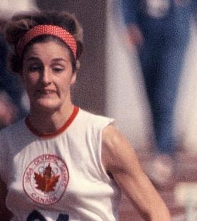 Dianne Gerace with short hair, wearing a red headband and a sleeveless shirt.