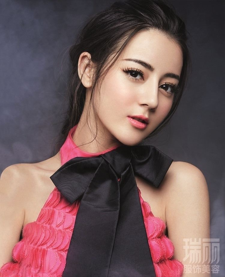 Dilraba Dilmurat with an angelic face while her hair tied up and wearing a pink sleeveless blouse with a black ribbon