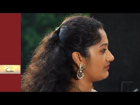 Dini Daniel posing sideview with her thick hair and big earrings.