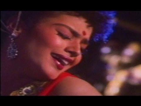 Disco Shanti singing and dancing while wearing a red dress and earrings
