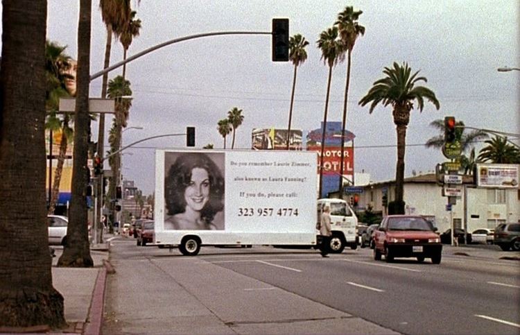 A movie poster of Do You Remember Laurie Zimmer? at the side of truck.