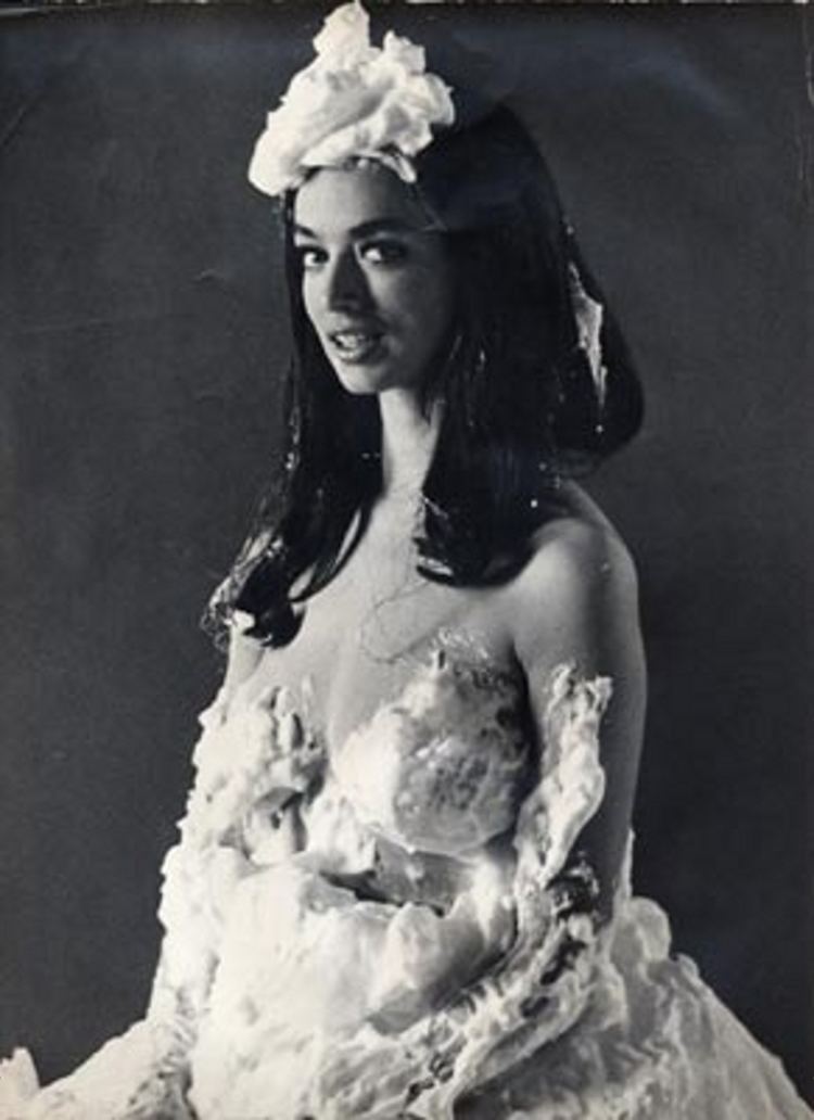 Dolores Erickson smiling while wearing a gown covered with whipped cream