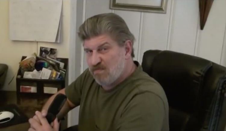 Don Shipley (Navy SEAL) wearing a gray shirt while sitting inside a room