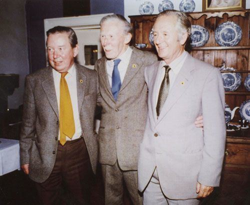 Donald Sinclair, James Alfred Wight, and Brian Sinclair standing and smiling together while wearing a suit