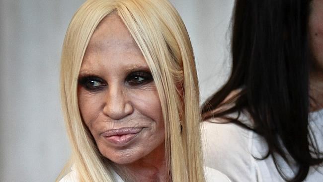 Donatella Versace smiling with a blonde hair and wearing a white coat during the 2014 MET Gala