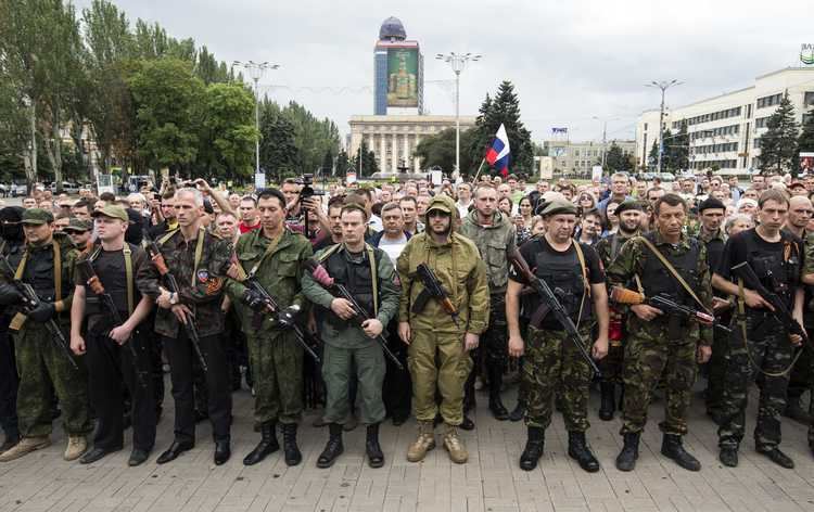 The Russian separatist forces of Donbass. Some of them are wearing military uniforms and carrying rifles.