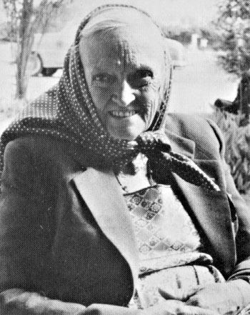 Dorothy Eady smiling while wearing a polka dot bandana, coat, and dress