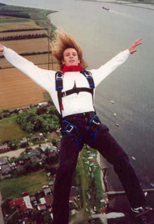 Dwain Weston with blonde hair, wearing white long sleeves and black pants while doing skydiving.