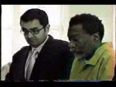 Dwight York at the trial court with his lawyer beside him while he is wearing brown long sleeves