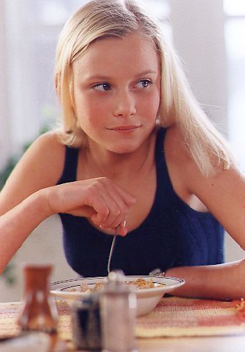 Ebba Hultkvist eating cereals, with blonde hair, and wearing a blue sleeveless top.