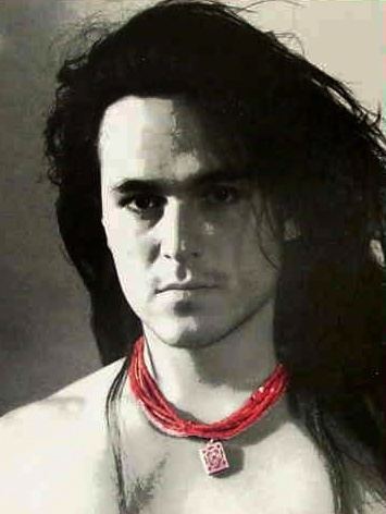 Eddie Chacon with long hair and wearing a red necklace