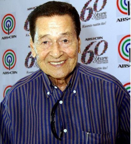 Eddie Garcia smiling while wearing a blue and gray striped long sleeves