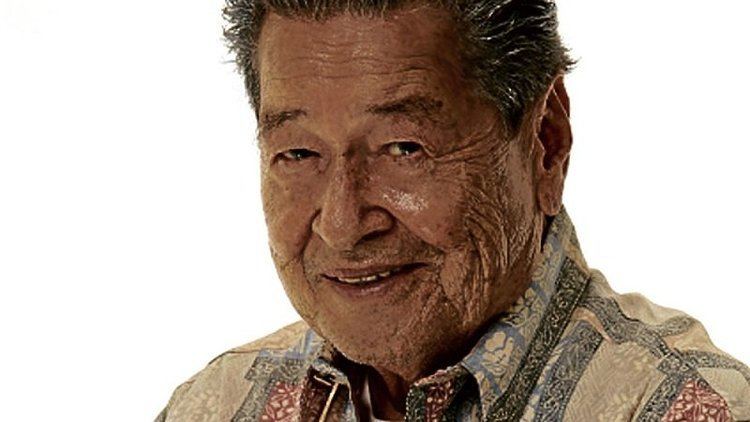 Eddie Garcia smiling while wearing a cream, green, and red polo