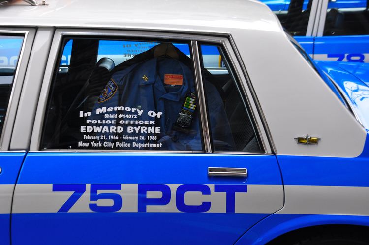 A blue and gray police patrol car with a police uniform and with the name of Edward Byrne.