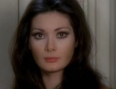 Edwige Fenech posing with her mouth closed and having black hair.