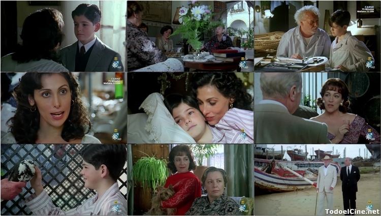 In the movie scene of El Palomo cojo, on the 1st row 1st column a person (left) crouching talking to Miguel Ángel Muñoz (right), has black curly hair wearing striped white shirt, in front Miguel Ángel Muñoz (right) is serious, listening while standing, has black hair, wearing a black and white shirt with black tie and gray coat. On the 1st row 2nd column three ladies talking over a table with a vase of white flowers and long green leaves with books on the right. 1st Lady (left) sitting, has short brown hair wearing gray printed long sleeve, 2nd lady (middle) is serious, sitting, looking down, has short black hair, wearing white dress, 3rd lady (right) is serious, sitting, has black hair, wearing black long sleeve,On the 1st row 3rd column, Joaquin Kremel (left) is serious, Sitting while looking at the kid (right) in a room with old machinery in front, has white hair white beard and a mustache wearing a white polo, next to him is Miguel Ángel Muñoz (right) is serious, standing while looking down, left hand on the machinery, has brown hair wearing white long sleeve polo.On the 2nd row 1st column, María Barranco is serious, mouth half open, has curly hair brown hair, wearing a gold round earrings, and white dress, On the 2nd row 2nd column, Miguel Ángel Muñoz (left) serious, looking straight while lying on the bed with white pillow has brown hair wearing a striped polo, behind him is María Barranco (right), smiling while whispering at the boy has short brown curly hair wearing round earrings. On the 2nd row 3rd column, a man and a woman talking in a room at the back is a winnowing tray hanging on the wall. The man (left) standing has white hair wearing a white polo and gray coat. On the 3rd row 1st column, Miguel Ángel Muñoz (right) is happy, touching the pigeon while looking at a black and white pigeon held by a person (left) at the back is a trellis, has brown hair wearing a striped top. On the 3rd row 2nd column, Carmen Maura (left) is smiling, looking to her left, while holding a brown dog with her left arm, at her right is a wall with a hanging plant, has short brown curly hair wearing red scarf and a red long sleeve dress, next to her the lady (right) is serious, sitting, looking at her left, looking at her left side, behind her left is a green curtain, has brown short hair, wearing a gray with black printed long sleeve. On the 3rd row 3 column, a two man walking in the middle of port with boats at the back, Joaquin Kremel (left) walking with a walking cane on his right hand, wearing a white hat white shirt under a while coat and white pants next to him is a man (right) walking, both hands at the back, has gray hair, wearing a white shirt with black necktie under the black coat and black pants.