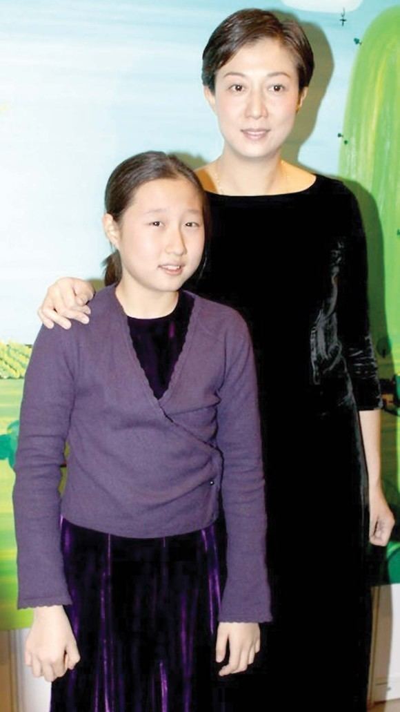 Elaine Ng Yi-Lei wearing a black dress with her daughter Etta Ng Chok Lam wearing a dress and a purple jacket