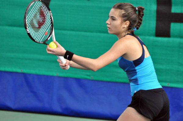 Elena Gabriela Ruse playing tennis while wearing a blue top and black shorts