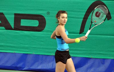 Elena Gabriela Ruse playing tennis while wearing a blue top and black shorts