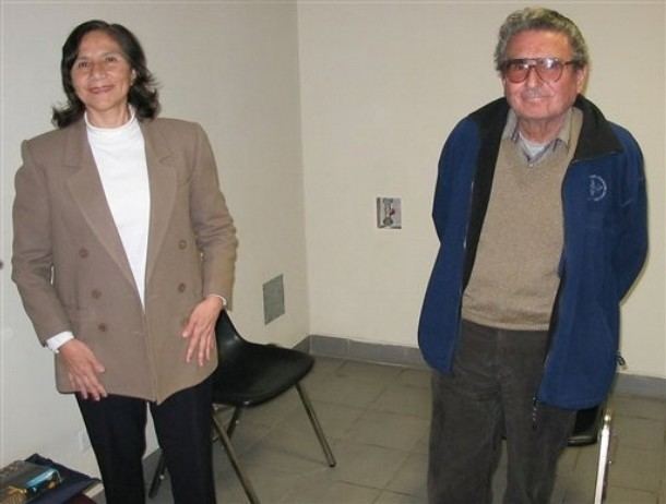Elena Iparraguirre smiling with Abimael Guzmán while wearing a brown blazer, white blouse, and black pants