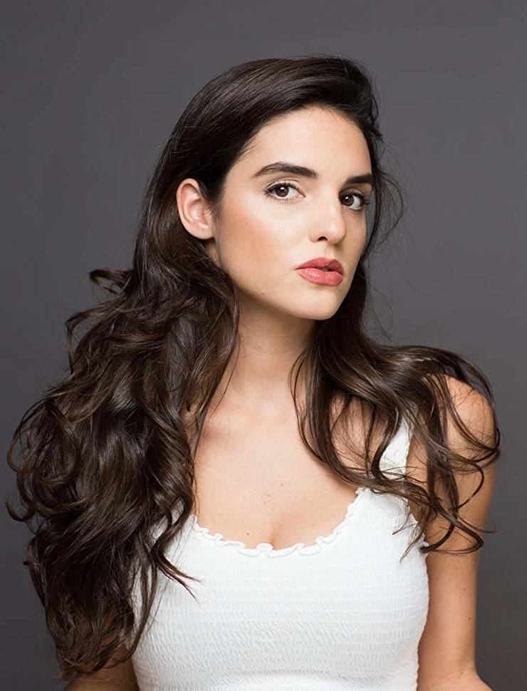 Elena Rusconi looking fierce with her wavy hair down and wearing a white top