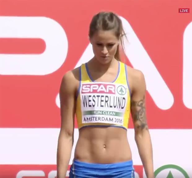 Elin Westerlund looking serious during the European Championship in Amsterdam, Netherlands in 2016 having tattoos on her left arm and wearing a yellow crop top and blue shorts