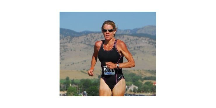 Ellen Hart Peña in her black bodysuit and shades while running