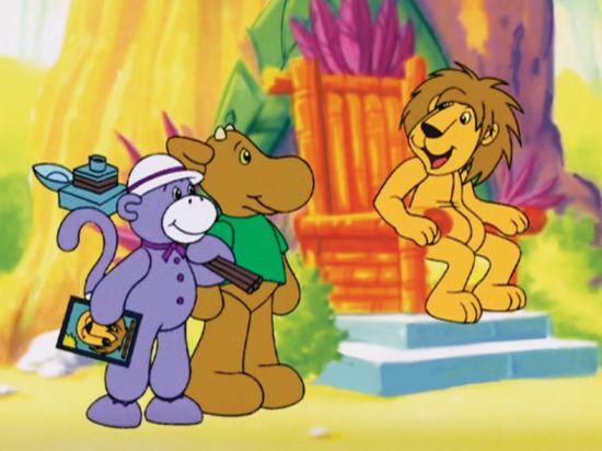 Socks (left), Elliot Moose (middle), and Lionel (right) from the TV Series Elliot Moose are smiling together. Socks is looking at Lionel with a purple skin tone holding a picture frame and a camera, and wearing a white hat and dark purple ribbon. Elliot is looking at Lionel with a dark brown skin tone wearing a green shirt and Lionel has a light skin tone sitting in the orange chair