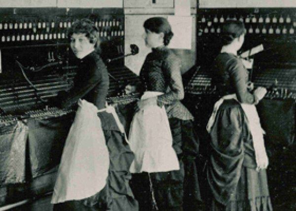 Emma Nutt and two companions operating telephone lines and wearing long dresses.