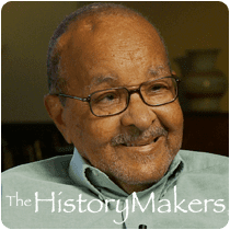 Emmett Chappelle smiling while looking at something, with a mustache, beard, and a caption on the bottom part, "The history makers". Emmett is wearing eyeglasses and light green polo