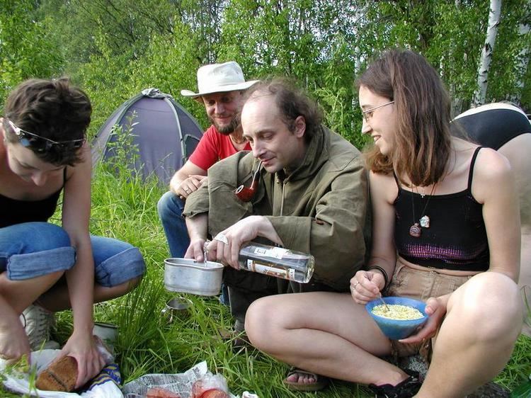 People preparing a meal on the grass while on camp during the Empty Hills Fest