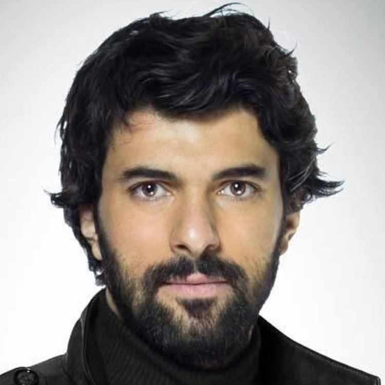 Engin Akyürek with mustache and beard while wearing a black jacket
