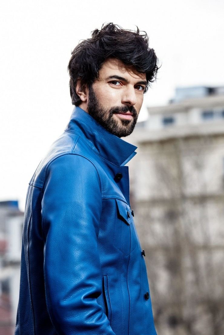 Engin Akyürek smiling while wearing a blue coat