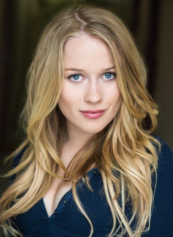 Erica Deutschman smiling, with blonde hair, and wearing a dark blue blouse.