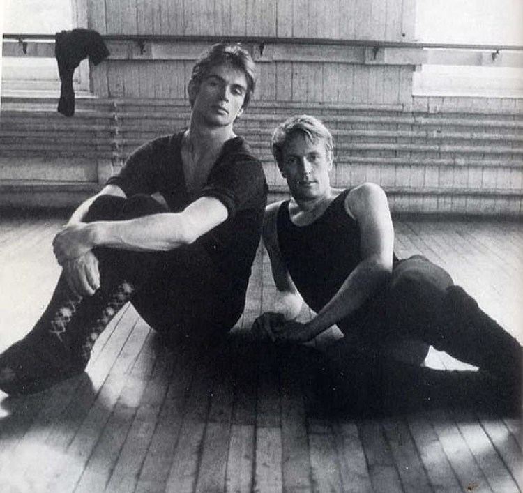 Erik Bruhn posing with Rudolf Nureyev inside a ballet studio wearing black ballet costume.