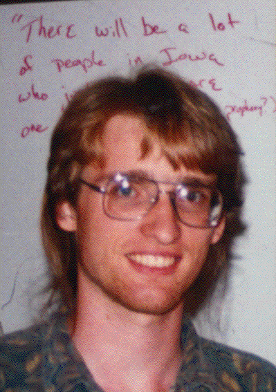 Erik Winfree smiling while wearing blue and brown polo and eyeglasses