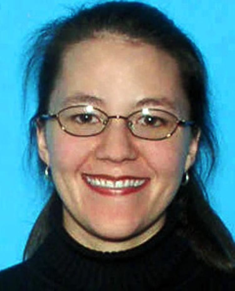 Esther Reed wearing a black shirt and a pair of eyeglasses