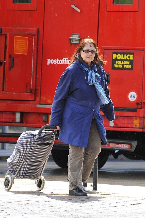 Eunice Spry strolling outside with luggage, in red truck background