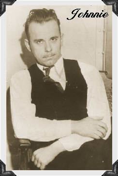 John Dillinger sitting on the chair while wearing white long sleeves, black vest, and necktie