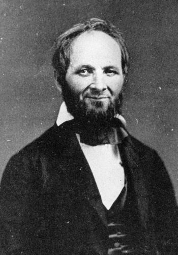 One of the members of the Church of Jesus Christ of Latter-day Saints with a smiling face and beard while wearing a black suit.