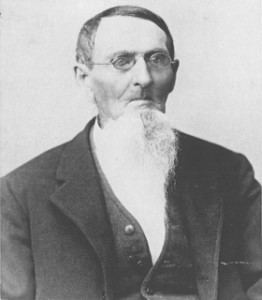 Philo Dibble with a beard, wearing eyeglasses and a suit.