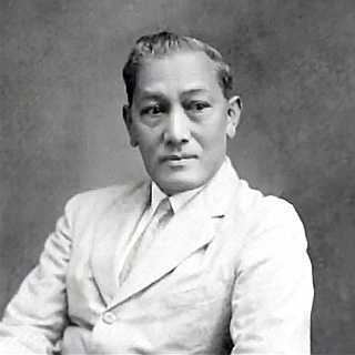 Fabián de la Rosa looking at the right side with a serious face while wearing a long sleeve under a necktie and coat