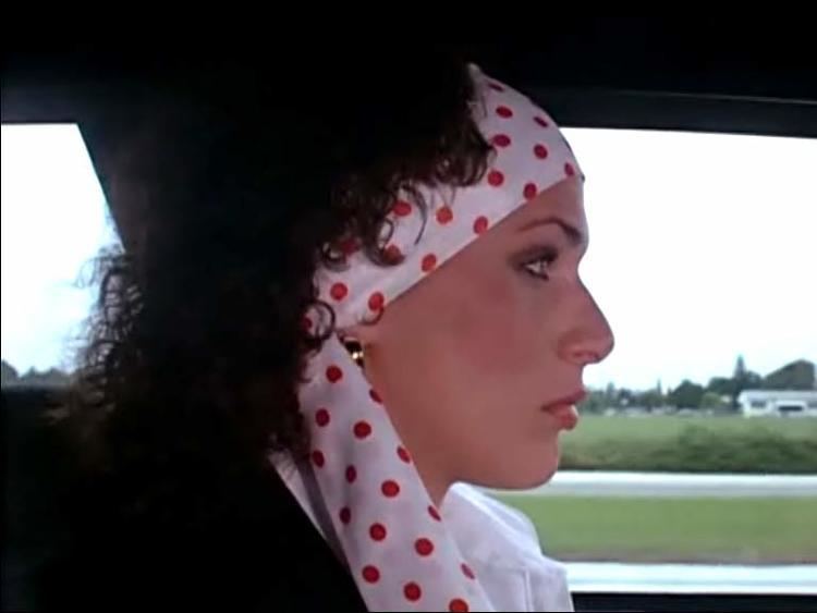 Faith Minton is inside the car while wearing a polka dot headband