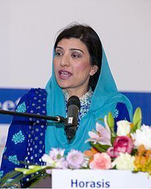 Farzana Raja wearing a blue dupatta scarf and blue traditional Indian clothing while talking.